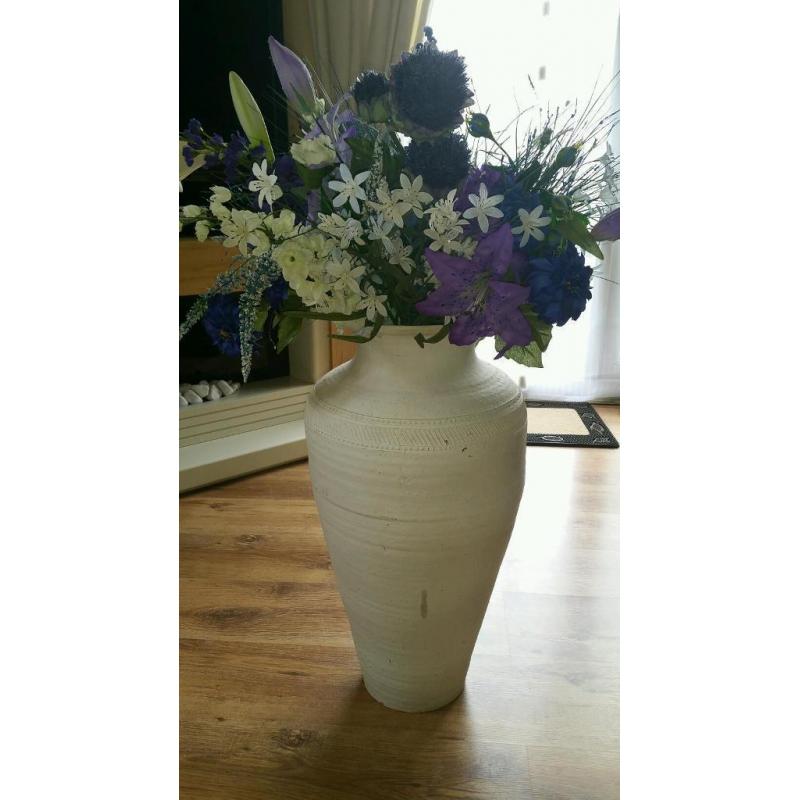 Tall white vase with artificial flowers
